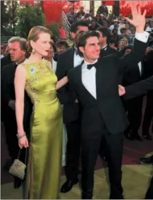  ?? CHRIS PIZZELLO — THE ASSOCIATED PRESS FILE ?? Tom Cruise and Nicole Kidman arrive for the 69th Annual Academy Awards in Los Angeles. Kidman wore an embellishe­d chartreuse Dior dress by John Galliano.