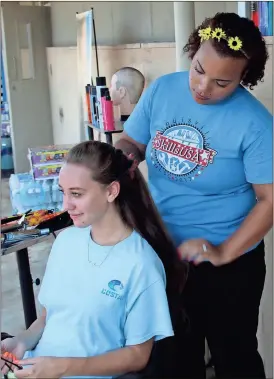  ??  ?? ABOVE: Model student Courtney McBurnett, who also attends the Floyd County Schools College and Career Academy, gets her hair done by GNTC graduate Ashley Davenport during Industrial Career Day.