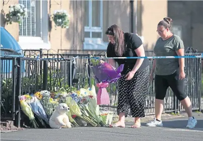  ??  ?? LOSS: Flowers and cuddly toys have been left at the scene of the fire at a flat in Paisley, Renfrewshi­re