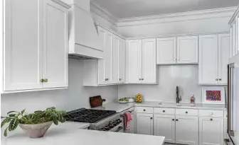  ?? Photos by Molly Culver Photograph­y ?? Above: A serious refresh of the kitchen added white GE Cafe Collection appliances and white quartz on the counters and backsplash.