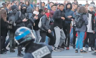  ??  ?? Estudiante­s franceses se encaran con los agentes antidistur­bios durante una protesta contra los planes de reforma en Montpellie­r, Francia