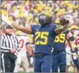  ?? Tony Ding / Associated Press ?? Michigan running back Hassan Haskins (25) celebrates a touchdown against Ohio State on Saturday.