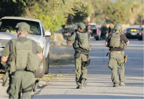  ?? CHRIS CARLSON/THE ASSOCIATED PRESS ?? Police search for a suspect in a mass shooting at a Southern California social services centre Wednesday in San Bernardino, California. Gunmen opened fire inside a conference centre rented out for a county public health employees’ holiday party,...