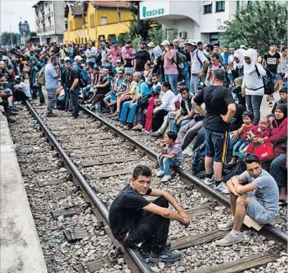  ?? DIMITAR DILKOFF / AFP ?? Esto es Europa. Centenares de inmigrante­s esperaban ayer en la estación de Gevgelija, en la frontera de Macedonia y Grecia, un tren en ruta a Serbia.