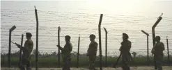  ??  ?? This photo taken on Feb 20, 2017 shows Indian Border Security Force (BSF) personnel patrolling along a fence at the India-Pakistan border at Wagah, some 35 km from Amritsar.