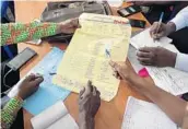  ?? JEROME DELAY/AP ?? Officials tally presidenti­al ballots Friday in Kinshasa, Congo, where the first results are expected Sunday.