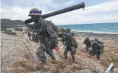  ?? Jung Yeon-Je / Getty Images ?? South Korean marines move into position on a beach during joint military drills with their American counterpar­ts last year.