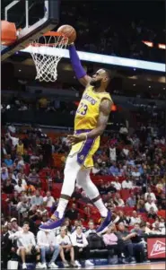  ?? BRYNN ANDERSON — THE ASSOCIATED PRESS ?? Lakers forward LeBron James scores during the first quarter against the Heat Nov. 18 in Miami.