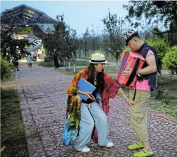  ?? Picture: REUTERS/TINGSHU WANG ?? ARTISTIC OUTLET: Flora Tan guides her son Jackie Zheng, 29, as he practises the accordion before performing with his band Star Kids, who like him are all adults with autism spectrum disorder, at a camp site at Beijing Eco Valley Smart Farm, in Beijing, China.