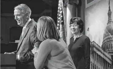  ?? Anna Moneymaker/getty Images ?? U.S. Sen. Kyrsten Sinema pats Sen. Rob Portman as Sen. Susan Collins looks on during a news conference Tuesday evening after the Senate passed the Marriage Equality Act in a 61-36 vote.