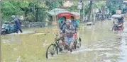  ?? PTI ?? Rickshaw pullers wade through a flooded street after heavy rain in Guwahati on Saturday.