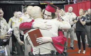  ?? Richard Brian Las Vegas Review-Journal @vegasphoto­graph ?? Arbor View High School senior Daxton Alyn Beck hugs Metro Sgt. Eric Hutchason at his graduation ceremony Saturday.