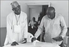  ?? NYANCHO NWANRI / REUTERS ?? Independen­t National Electoral Commission officials collate results from polling units in Yola, Nigeria, on Sunday.