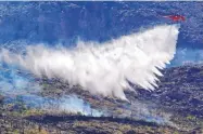  ?? MATT YORK/ASSOCIATED PRESS ?? A helicopter drops water on the Bighorn Fire in the Santa Catalina Mountains, north of Tucson, on Friday. Hundreds of homes are threatened by the blaze.