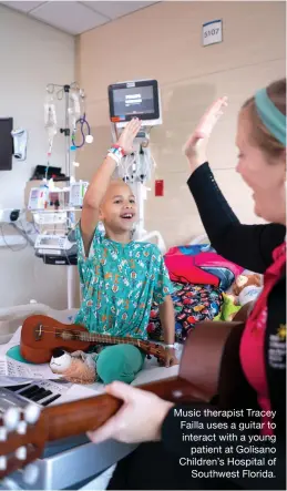  ?? ?? Music therapist Tracey Failla uses a guitar to interact with a young patient at Golisano Children’s Hospital of Southwest Florida.