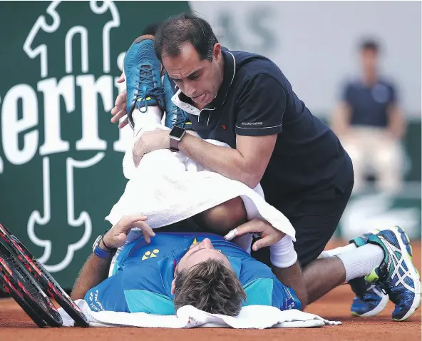  ?? — GETTY IMAGES ?? Stan Wawrinka of Switzerlan­d receives treatment for an ailing back during the men’s singles fourth-round match against Gael Monfils of France at the French Open on Monday. Wawrinka posted a three-set win to reach the quarter-finals.