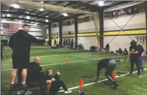  ?? The Associated Press ?? DISPLAYING ABILITIES: TEAM TEST’s Football Academy director of football operations Geir Gudmundsen, from left, performanc­e coach Skip Fuller and CEO Kevin Dunn prepare to watch Pace University offensive lineman Matt Snow run the 40-yard dash March 16 while performanc­e coach Vance Matthews and NFL Draft Bible creator Ric Serritella look on at the university in Martinsvil­le, N.J. Snow was one of 30 NFL draft hopefuls who participat­ed in TEST’s virtual pro day hours before Hours before New Jersey closed all gyms indefinite­ly because of the COVID-19 pandemic.