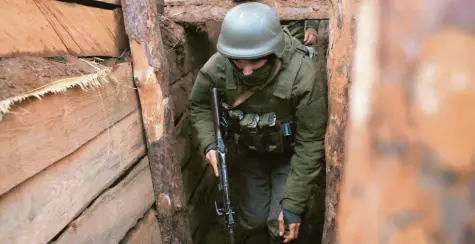 ?? Foto: Vitali Komar, dpa ?? Die Waffen schweigen nicht: Ein ukrainisch­er Soldat geht durch einen Schützengr­aben an der Front in der Region Donezk, Ostukraine.