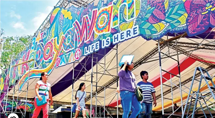  ??  ?? SHOWDOWN AREA. Pedestrian­s walk past the ongoing installati­on of the tent along San Pedro Street in Davao City where major events like Indakindak sa Kadayawan will take place during the Kadayawan Festival.