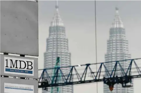  ?? — AFP ?? KUALA LUMPUR: The 1 Malaysia Developmen­t Berhad (1MDB) logo is seen on a billboard at the funds flagship Tun Razak Exchange under-developmen­t site in Kuala Lumpur yesterday.