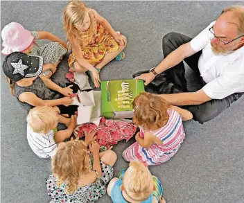  ?? FOTO: NORBERT PRÜMEN ?? Dietmar Winkels, Vorsitzend­er des Willicher Jugendhilf­eausschuss­es, packte bei der offizielle­n Eröffnung der Einrichtun­g mit den Kindern Geschenke aus.