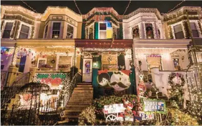  ?? BALTIMORE SUN FILE ?? Neighbors on 34th Street in Baltimore’s Hampden neighborho­od have decked their homes in lights for 70 years-plus.