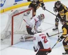  ?? AP PHOTO ?? ALL EVEN: Jake Guentzel (59) flips the puck past Capitals goalie Braden Holtby in the Penguins’ 3-1 victory last night, which tied the series at two games apiece.