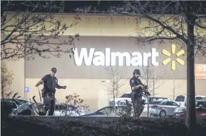  ?? — Gambar AFP ?? CARI PETUNJUK: Anggota polis memeriksa kawasan sekitar Walmart selepas tiga orang mati ditembak di gedung beli-belah di Colorado itu pada petang kelmarin.