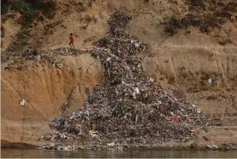  ?? Danish Siddiqui / Reuters ?? Rubbish is piled high on the Ganges’ banks, while its water is a sickly grey