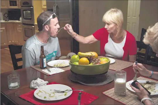  ?? Photograph­s by Katie Falkenberg Los Angeles Times ?? ERIC LUND with aunt Melissa Boggs at a family dinner in Ludington. His mother says he’s self-conscious — embarrasse­d that he needs help with simple tasks.
