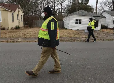  ?? (Arkansas Democrat-Gazette/Thomas Metthe) ?? Workers from Liberty Utilities walk through a Pine Bluff neighborho­od Thursday. The workers, who didn’t wish to be identified, said they were going street to street in the city looking for water leaks.