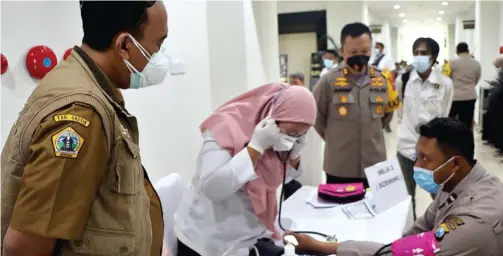  ?? GALIH WICAKSONO/JAWA POS ?? PERCEPATAN: Kepala Dinkes drg Syaifuddin Ghozali (kiri) bersama Kapolres AKBP Arief Fitrianto memantau pelaksanaa­n vaksinasi gelombang kedua di Mapolres Gresik yang dimulai kemarin.