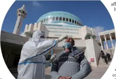  ?? Photo: AFP ?? A member of the Jordanian health ministry’s epidemiolo­gical investigat­ion team takes a random nasal swab to test for COVID-19 from a man leaving the King Abdullah I mosque following the Friday noon prayers, in the capital Amman, on December 18.