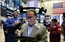  ?? RICHARD DREW — THE ASSOCIATED PRESS ?? Stock trader Salvatore Suarino works at the New York Stock Exchange, Friday.