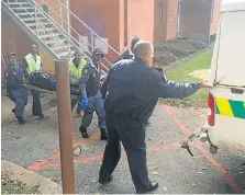  ?? Picture: ANELE MJEKULA ?? GRIM TASK: Police remove one of the bodies