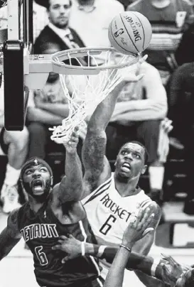  ?? Smiley N. Pool photos / Houston Chronicle ?? The ball hangs on the rim as Rockets forward Terrence Jones goes up for a tip against Pistons forward Josh Smith, who is nearly entangled in the net.