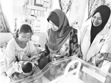  ??  ?? Hamisa visiting a baby born on January 1, 2018 yesterday and who received ADAM50 incentive at the Tawau General Hospital.