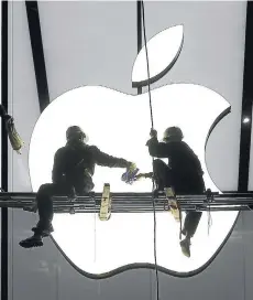  ?? FOTO: REUTERS ?? Dos trabajador­es preparan la apertura de una tienda de Apple en Hangzhou, China.