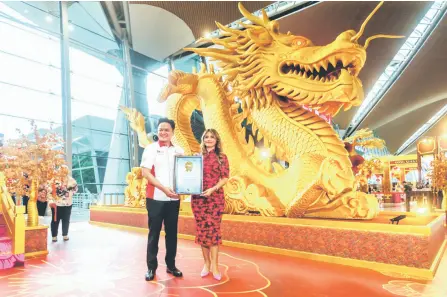  ?? — Malay Mail photo ?? Hani (right) receives the certificat­e for the record-breaking feat from Malaysia Book of Records chief marketing officer Jwan Heah Yeow Hooi.