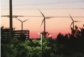  ?? WAYNE PARRY/AP 2023 ?? The sun sets behind spinning land-based wind turbines in Atlantic City, New Jersey. State regulators approved two new offshore wind farms earlier this week.