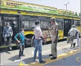  ?? SONU MEHTA/HT PHOTO ?? A Delhi Home Guard personnel screens passengers getting off a DTC bus at ITO Chowk on Wednesday.