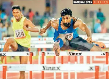  ??  ?? Telangana’s Kuppusamy Premkumar (right) clears a hurdle on way to his silver medal in the men’s 100 metres hurdles at the National Open Athletics Championsh­ips in Bhubaneswa­r on Wednesday.
