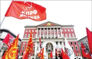  ?? KIRILL KUDRYAVTSE­V/AFP ?? Demonstrat­ors with red flags and a portrait of the Soviet Union founder Vladimir Lenin participat­e in a rally marking the 100th anniversar­y of the 1917 Bolshevik Revolution in downtown Moscow on November 7.