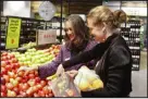  ?? NICK PERRY — THE ASSOCIATED PRESS ?? Catherine Langabeer, left, head of sustainabi­lity at the Countdown chain of supermarke­ts, and Associate Environmen­t Minister Rachel Brooking put fruit in reusable polyester mesh bags Thursday at a supermarke­t in Wellington, New Zealand.