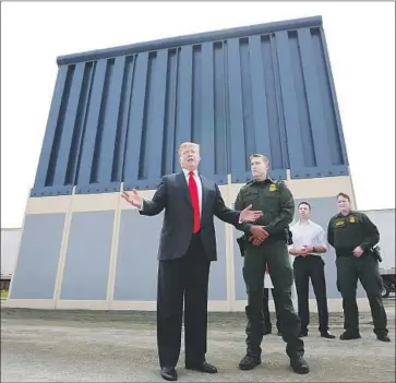  ?? K.C. Alfred San Diego Union-Tribune ?? PRESIDENT TRUMP views prototypes of his long-promised Mexico border wall near the Otay Mesa Port of Entry in San Diego. On his first visit to the state as president, he also attended a fundraiser in Beverly Park.