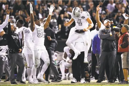  ?? Photos by Ezra Shaw / Getty Images ?? Khalil Mack (52) and Derek Carr (4) celebrate after Michael Crabtree’s touchdown with no time left on the clock.