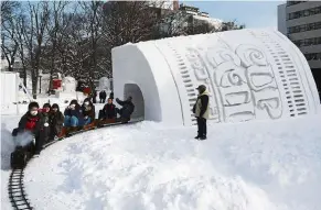  ?? — aFP ?? Chilly entertainm­ent: People riding a mini steam locomotive through a snow tunnel during the festival in sapporo.