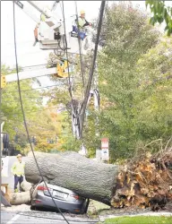  ?? Arnold Gold / Hearst Connecticu­t Media file photo ?? Crews from United Illuminati­ng work to restore power on Howard Avenue in New Haven, where an oak tree fell onto power lines and crushed a car on Oct. 30, 2017.
