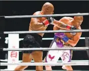  ?? Joe Scarnici Getty Images ?? MIKE TYSON, back in the ring for the first time in 15 years, connects with a left against Roy Jones Jr.