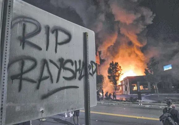  ??  ?? An Atlanta Wendy's restaurant burns after protests sparked by the shooting death of Rayshard Brooks (inset below). Picture: AP